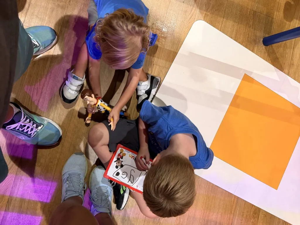 Kids in playing with toys on the floor in line. Toys are one of my Disney World Tips