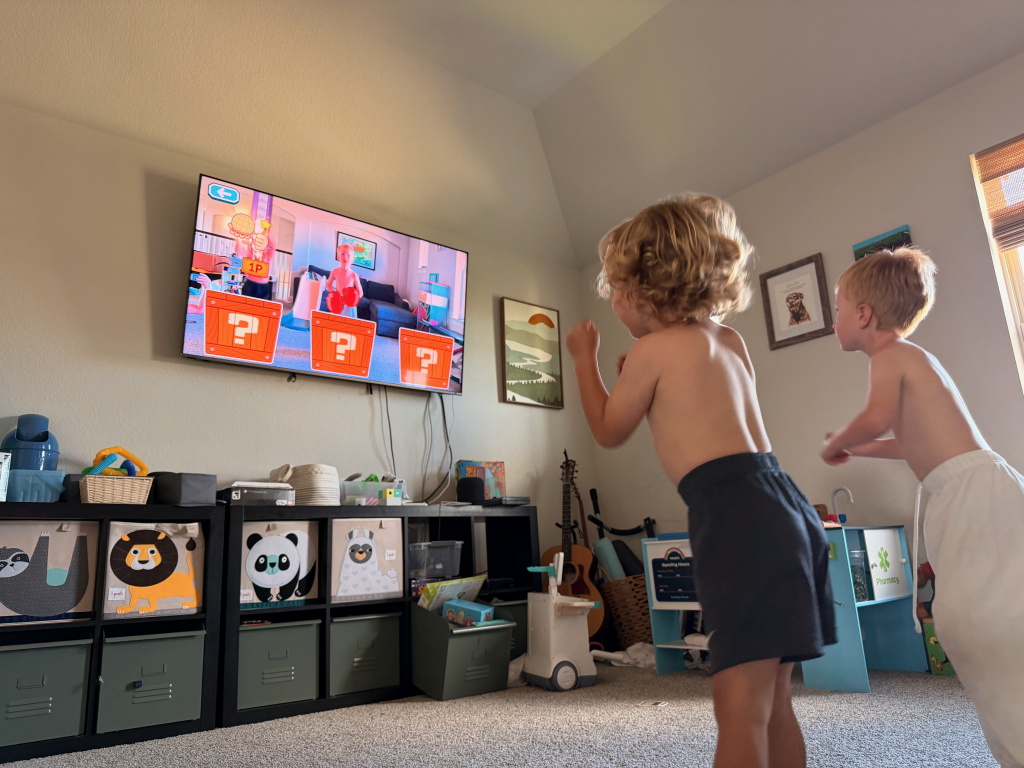 Two children jumping in front of a TV playing game for my NEX Playground Review