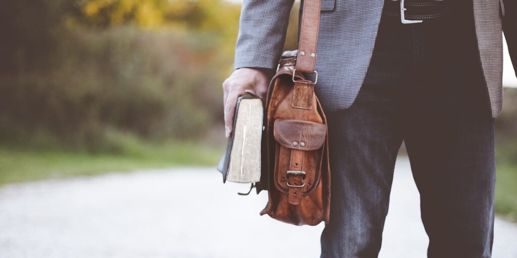 I’m Leaving Education: 5 Things That Drove Me Away 6 A Man holding a book and a bag symbolizing leaving education and the classroom