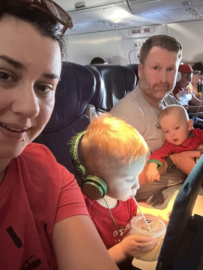 Christmas Regressions, New Years Resolutions, and I Don’t Want to Do Anything 5 Family of four on an airplane. A man holding the baby, a kid with headphones drinking a juice from a straw, and mom taking the picture