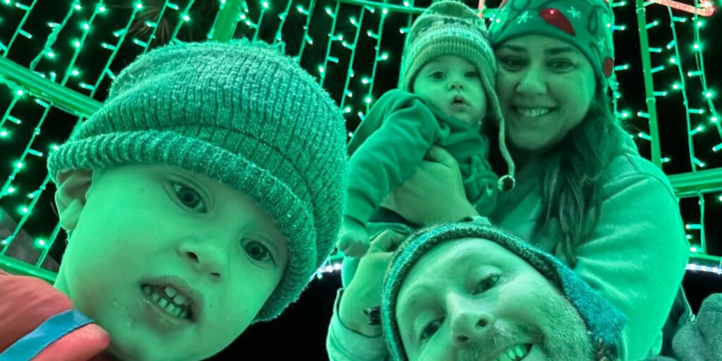 Christmas Regressions, New Years Resolutions, and I Don’t Want to Do Anything 3 A family of four looking into the camera with green christmas lights tinting the image