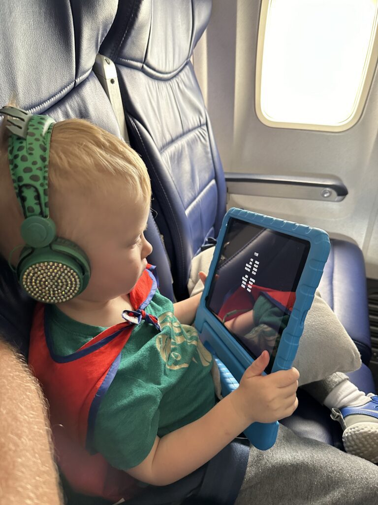 The Tablet War | Should Toddlers Have Tablets 4 A boy sitting in an airplane seat using a tablet