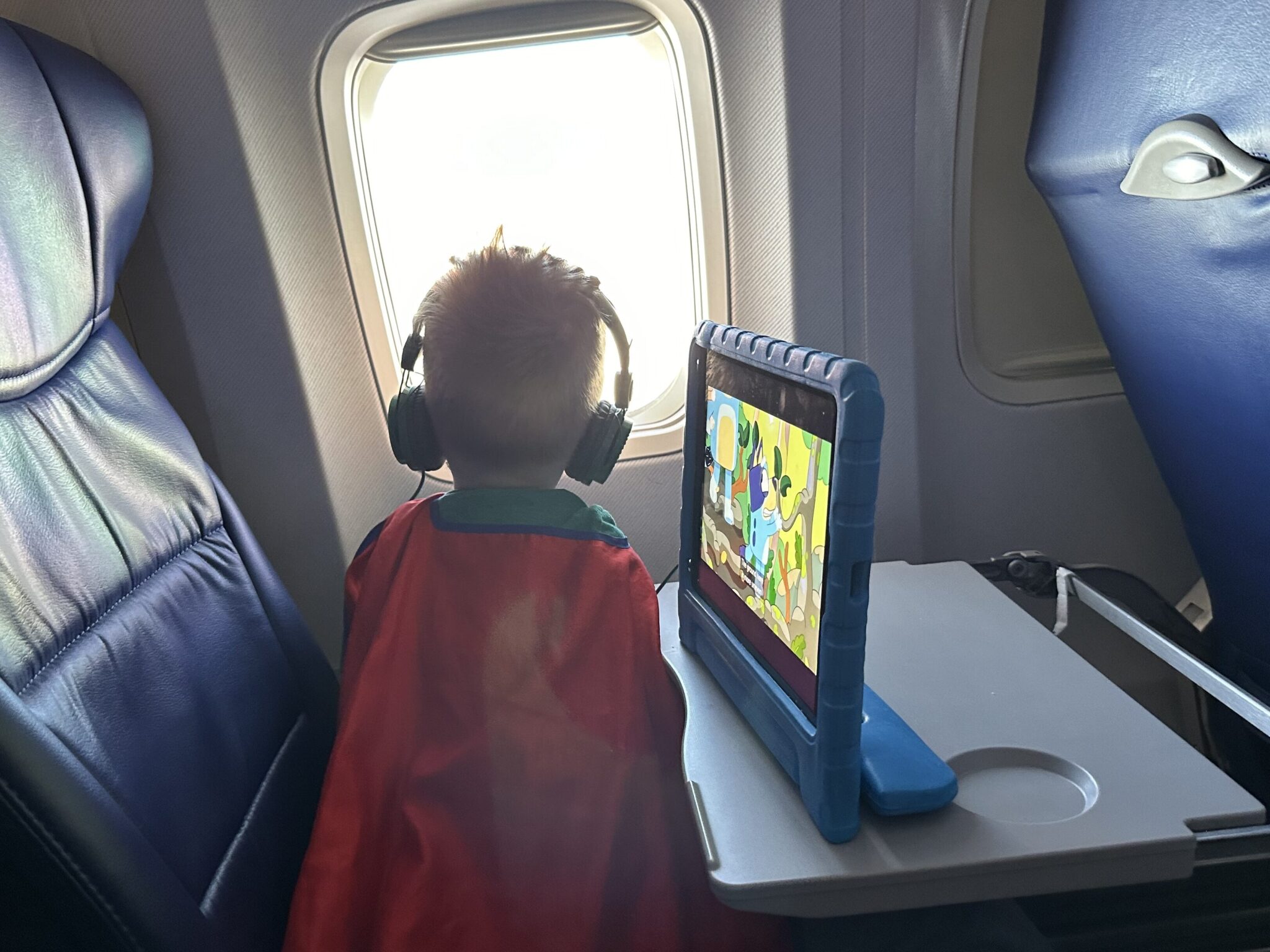 The Tablet War | Should Toddlers Have Tablets 5 A boy looking out the window with his tablet to his side.