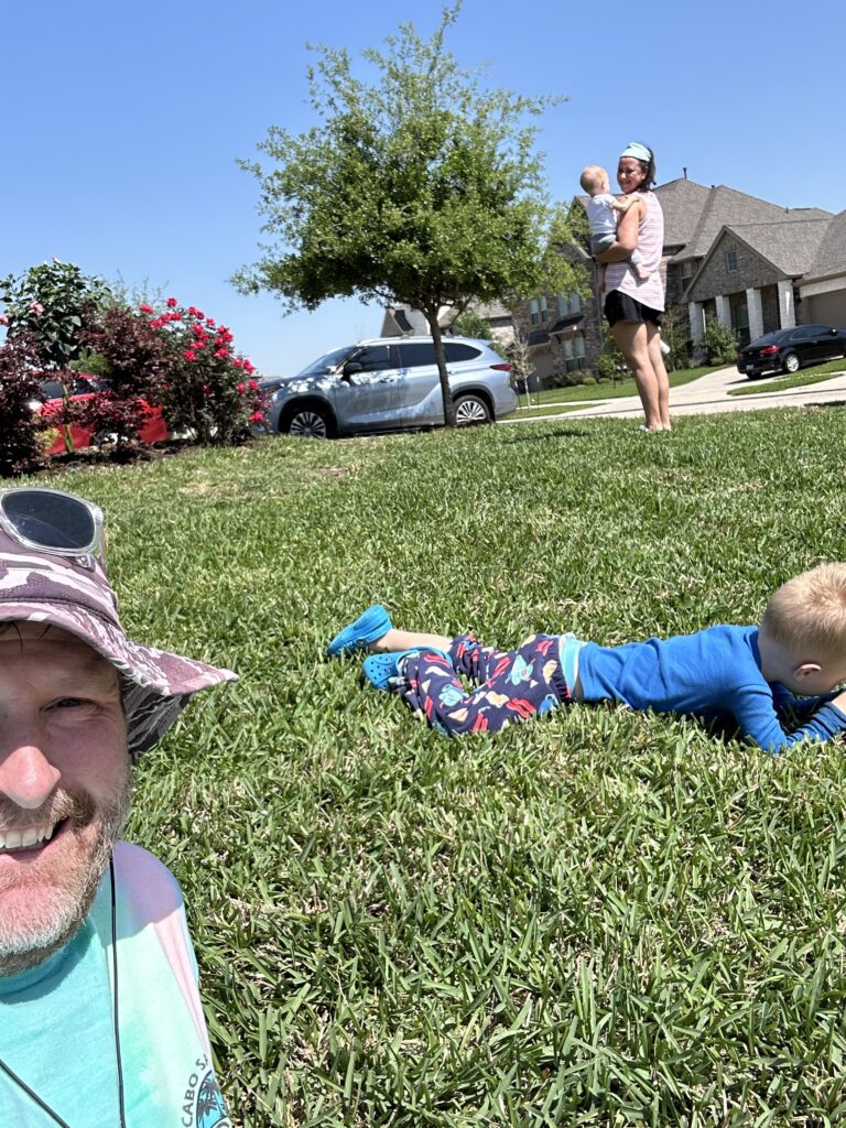 The Best Parts of Being A Stay At Home Dad 5 a family laying on a lawn