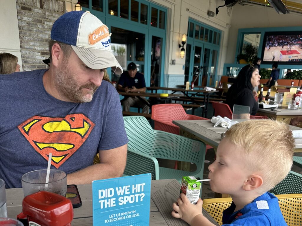 Threeanger Attitude and Spring Break Adventures 7 a father looking at his son at the dinner table in a restaurant