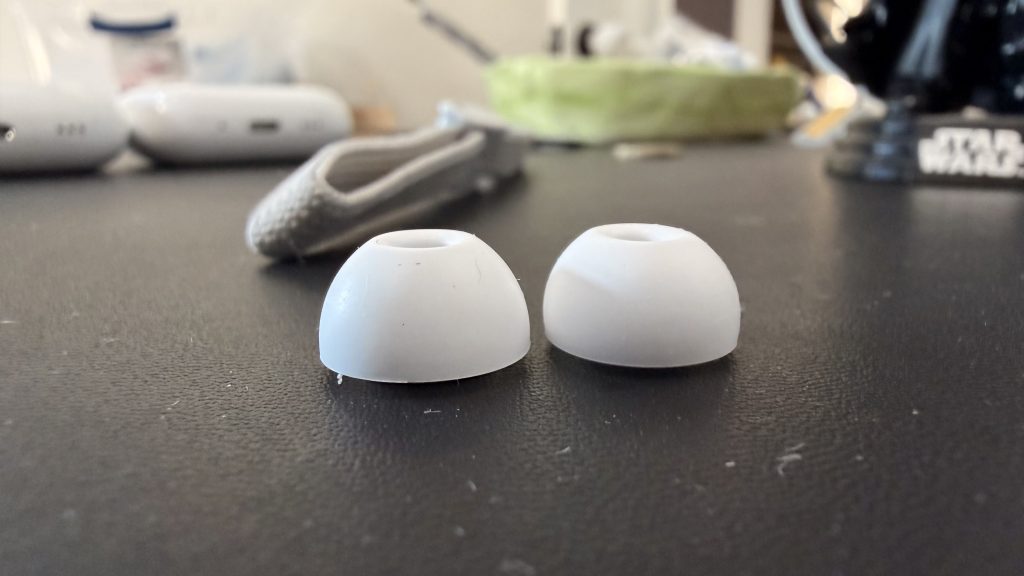 AirPods Pro 3 Review: Real-Life Impressions Of Fit, Sound Quality, Health Features, And More 5 An AirPod Pro 2 Large ear tip next to an AirPods Pro 3 Large ear tip on a desk