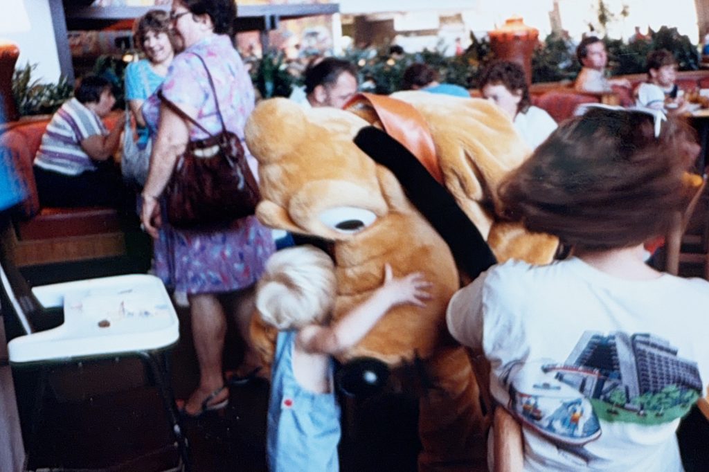 Conquering Disney World— My First Visit in Almost 40 Years 3 An old photo graph of a boy hugging Pluto at Disney World in the 80s
