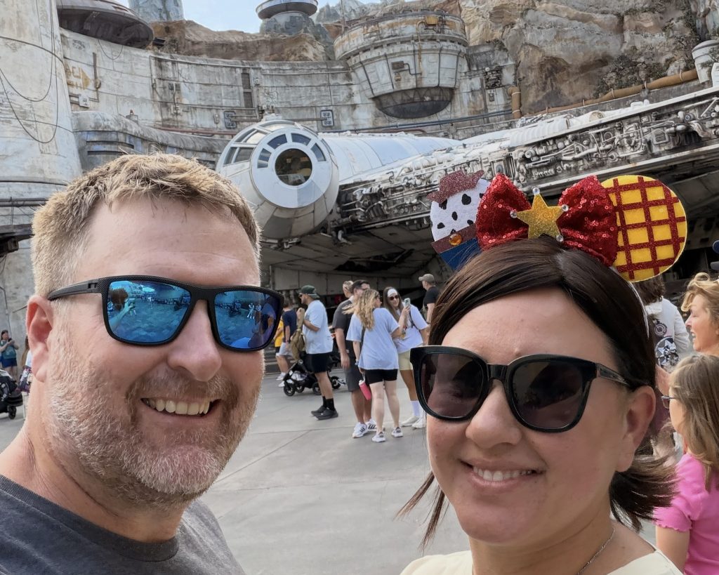 Conquering Disney World— My First Visit in Almost 40 Years 15 A man and woman in front of the Millenium Falcon at Galaxy's Edge in Disney World Hollywood Studios
