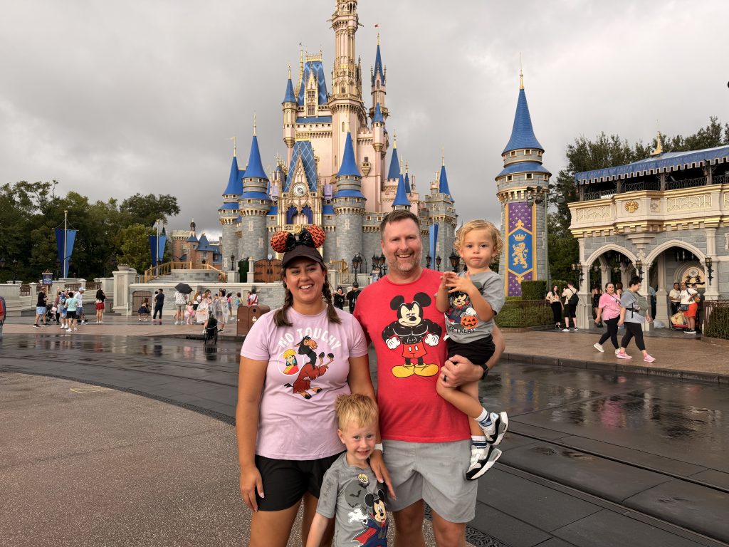 Conquering Disney World— My First Visit in Almost 40 Years 28 a family in front of the castle at the Magic Kingdom in Disney World