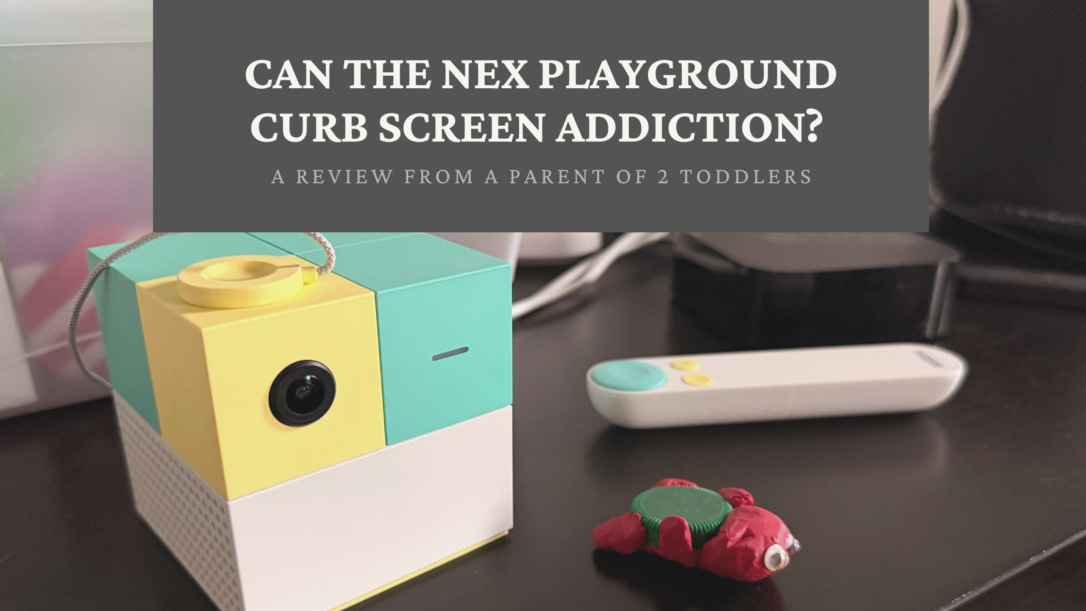 NEX Playground review of a gaming system and remote on a dark surface with a child's clay toy