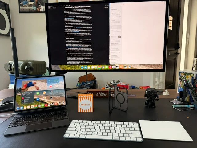 An iPad connected to a Studio Display with a Magic Keyboard and trackpad on a desk, illustrating the need for an iPad renaissance.